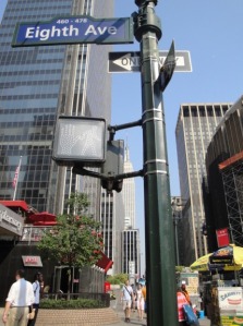 Signs points in many directions on street corner in NYC.